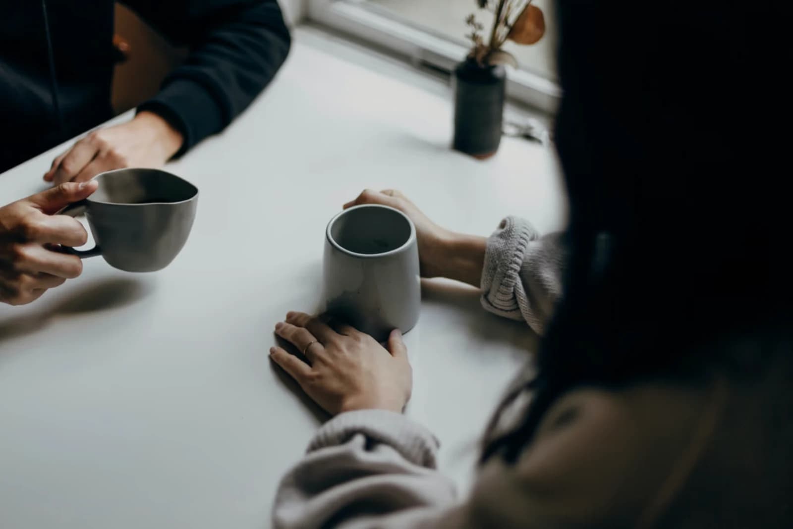 Two people talking over coffee during a working conversation