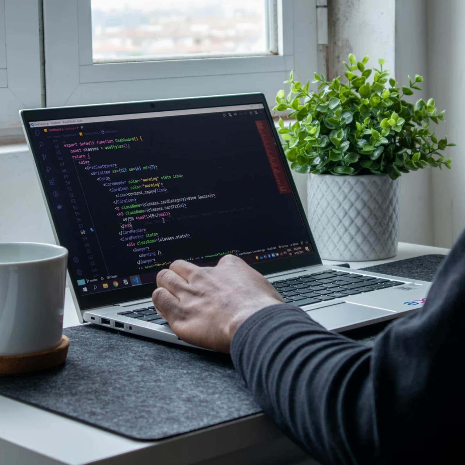 Engineer working at a desk with code on screen
